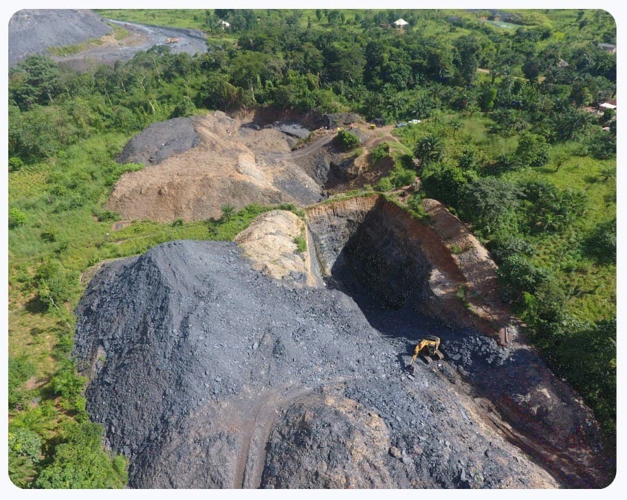 Aerial view of an open-pit mining operation with excavator